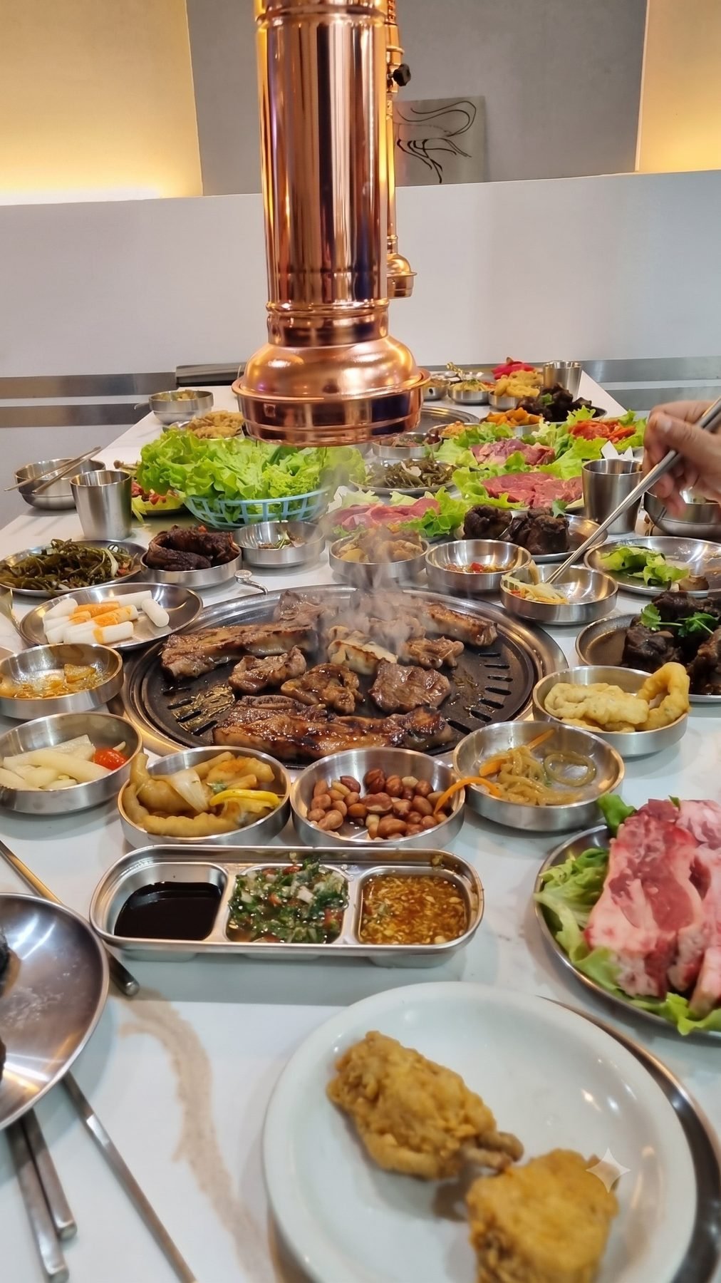 Mesa con parrilla asiática y campana de cobre